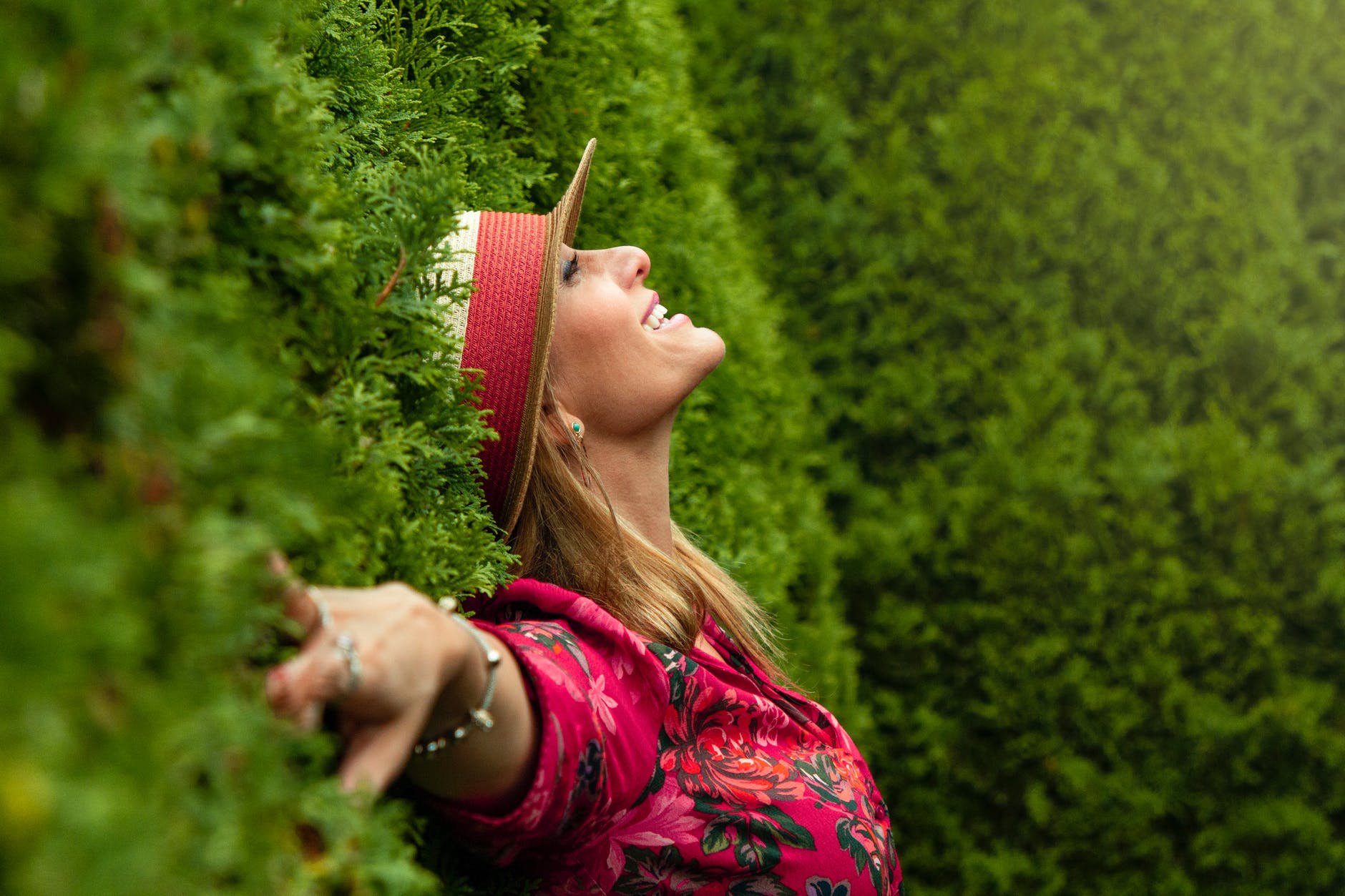 woman in red floral shirt lying on grass field