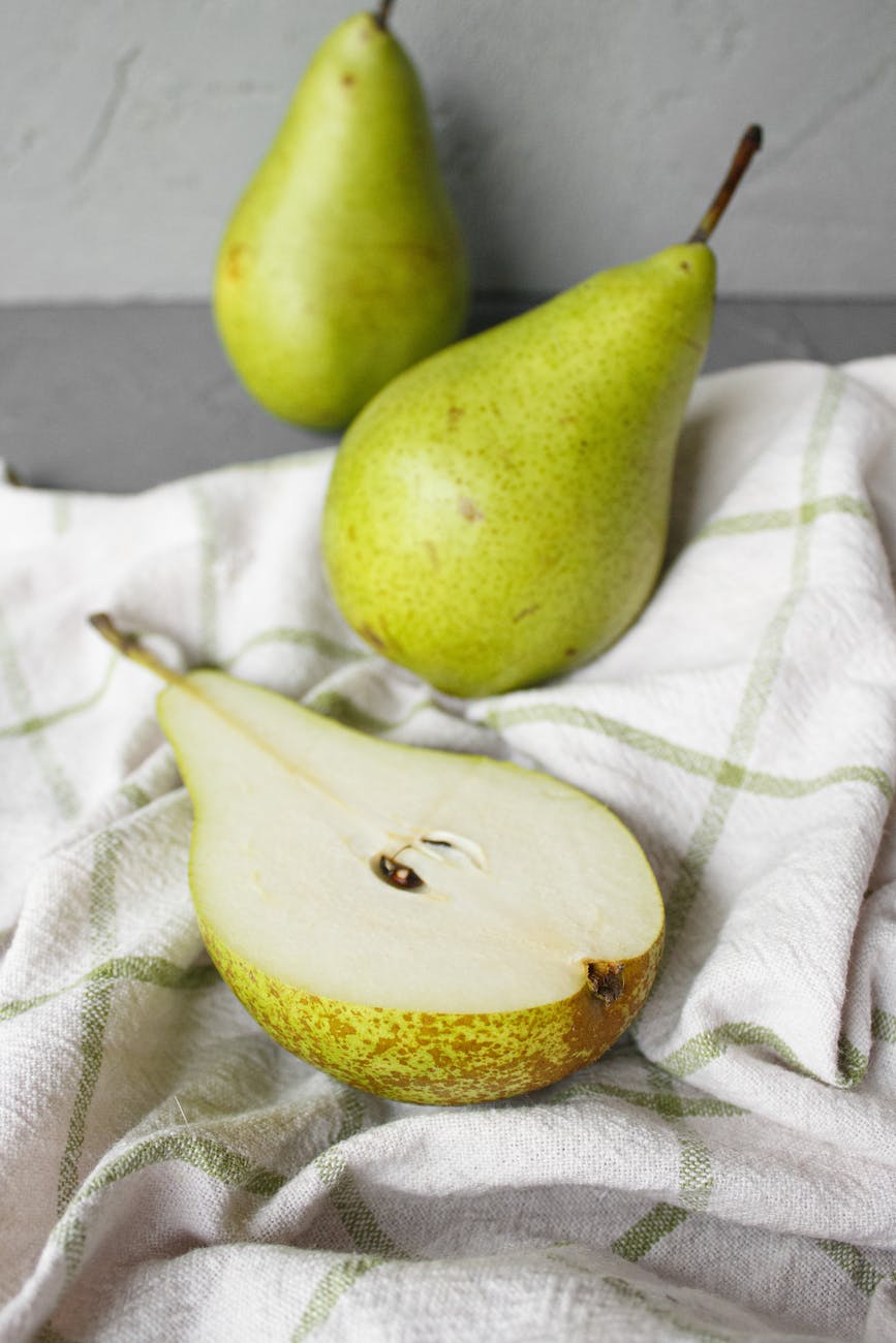 green pears placed on cloth on table