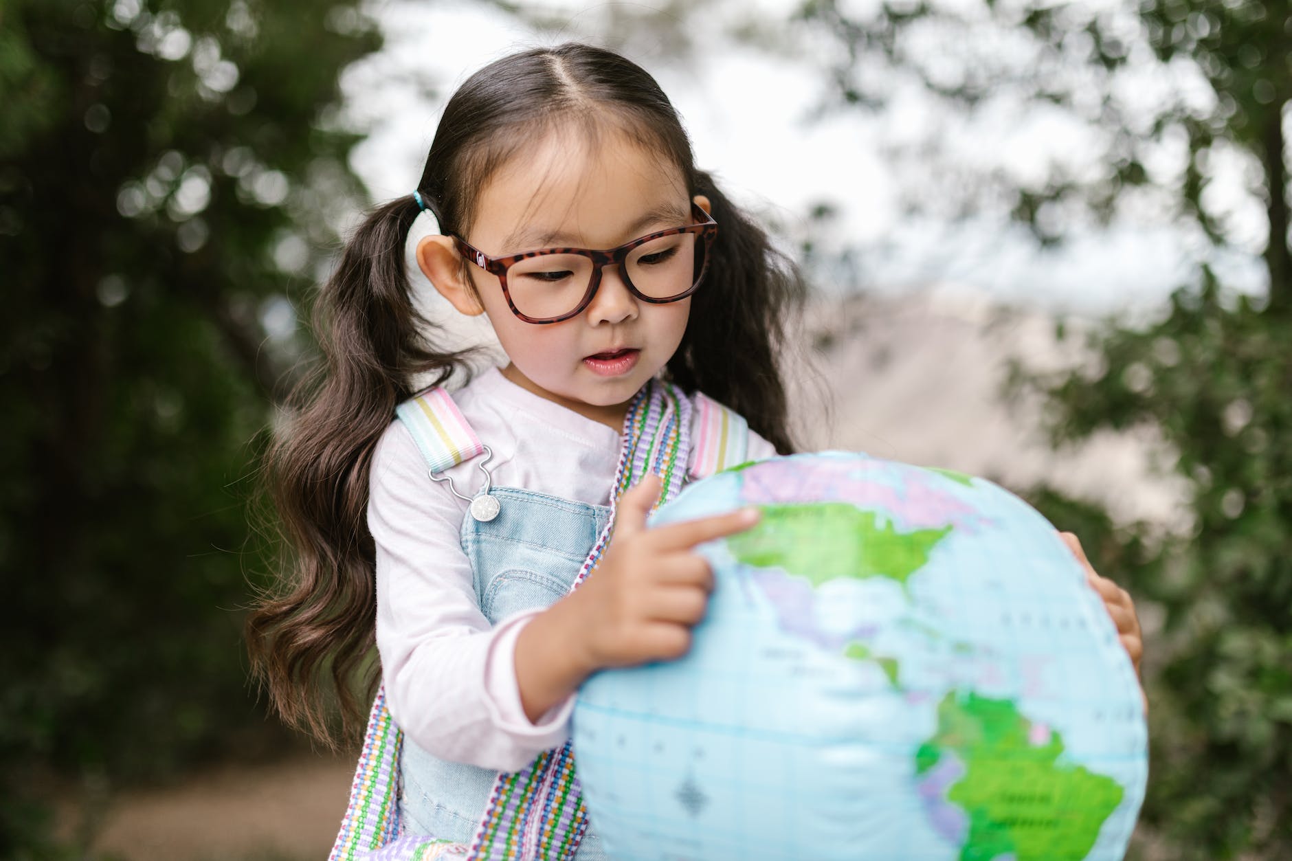 a girl pointing on a globe