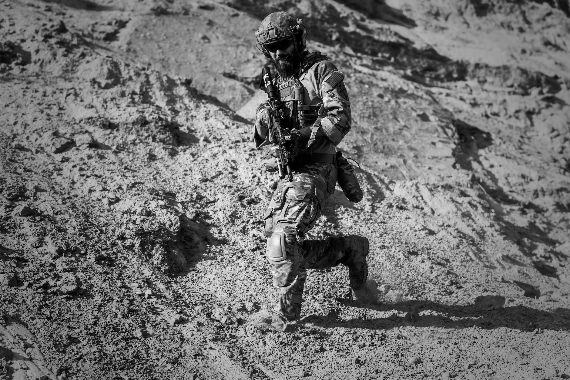 man in army full combat uniform carrying rifle
