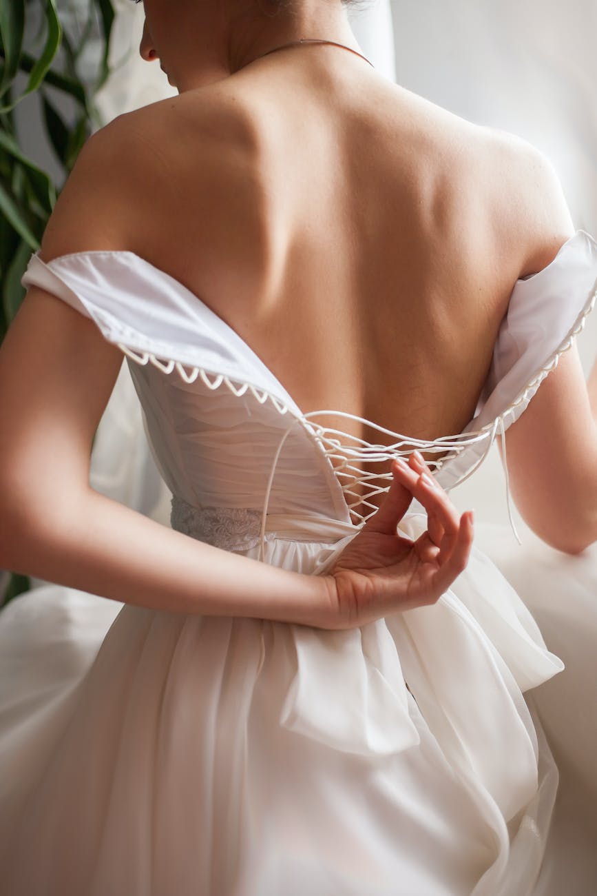 back view of bride unzipping wedding dress