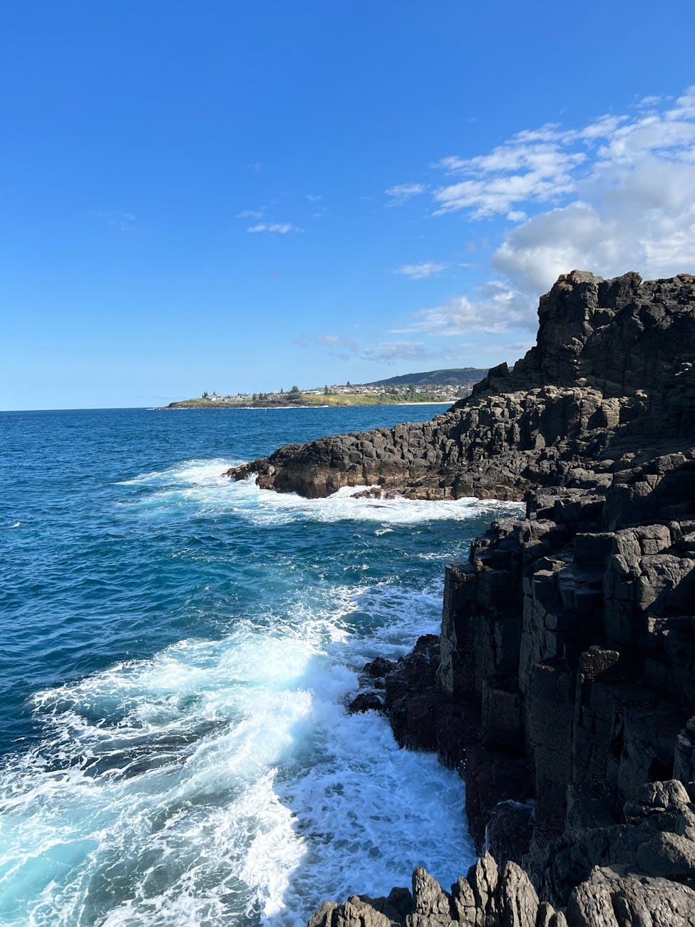 sea waves breaking against a rocky coast and a cliff