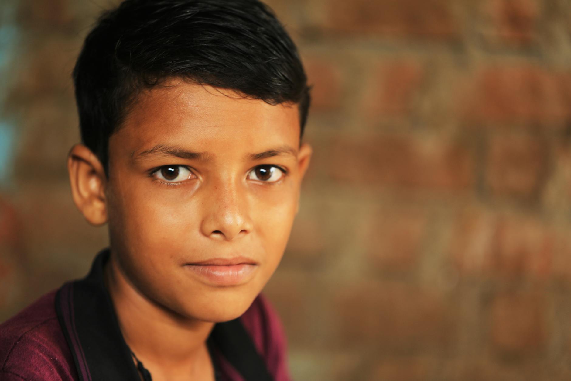 photo of boy in black and red collared shirt